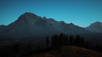 A view of a mountain range with trees in the foreground photo