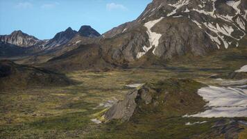 A mountain range covered in snow and grass photo
