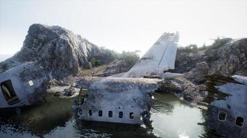 Plane wreck on the beach with rocks near ocean photo