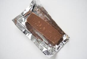 A sweet chocolate bar in a package. A waffle chocolate bar. photo