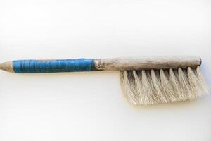 An old brush with a wooden handle on a white background. An old detail. photo