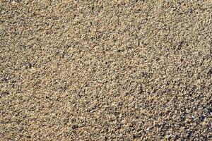 The river sand is coarse-grained. Small pebbles of river sand. Macrophotography of sand. photo