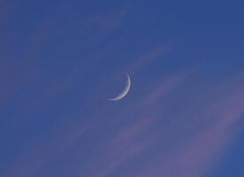 A moon moon in the blue sky. The phase of the moon. photo