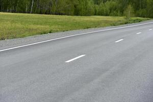 High-speed asphalt road in the spring forest. Country road. photo