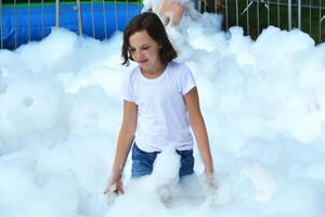 happy girl with foam on her head, in wet clothes at a foam party, in wet clothes at a foam party photo