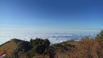 The view of the sea of clouds with blue sky from the top of mount lawu is suitable for use as a background with a natural theme photo