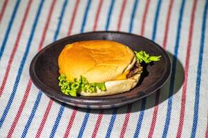 A portion of beef cheeseburger on a mortar looks like a holiday picnic photo