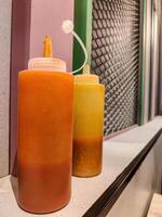 a bottle of ketchup and chili sauce at a fast food restaurant photo