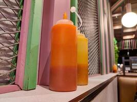 a bottle of ketchup and chili sauce at a fast food restaurant photo