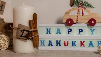 Zoom in out Candles with advent calendar Lightbox with text HAPPY HANUKKAH Traditional Burning Christmas Wax Candles with numbers counting down for Christmas. Beautiful Advent At Home. Festive Candlelight And Dark Background. Christmas eve video