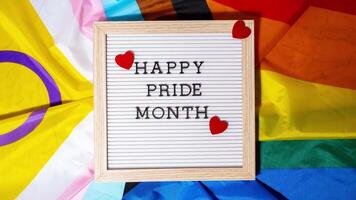 Stop motion HAPPY PRIDE MONTH frame on Rainbow LGBTQIA flag made from silk material. Symbol of LGBTQ pride month. Equal rights. Peace and freedom. Support LGBTQIA community. Diversity equality video