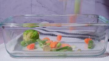Falling Frozen mixed vegetables in glass container for long-term storage. Stocking up vegetables for winter storage. Deep freezing of vegetables. defrosting Assortment of frozen vegetables video