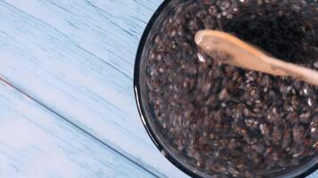 Preparing superfood water drink rich in Omega 3 fatty acids. Pouring coconut water. Adding soaked chia seeds and lemon detox Breakfast. Clean eating, weight loss, dieting food concept Vegetarian Healthy cooking process video