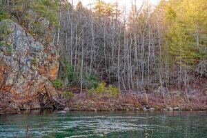 Creek with bluffs and bare trees photo