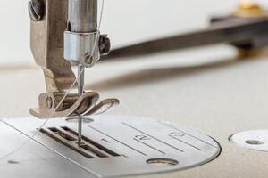 Sewing machine needle with thread and fabric photo