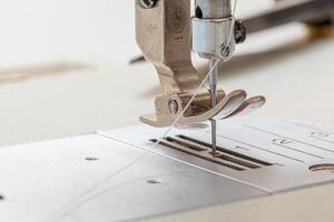 Sewing machine needle with thread and fabric photo