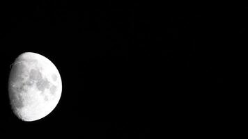 Timelapse. A glowing huge moon as seen from earth through the atmosphere against a starry night sky. A large moon moves across the sky, the moon moving from the left frame to the right. video