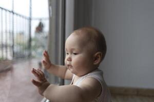 A curious baby exploring the world through a window, full of wonder and innocence photo