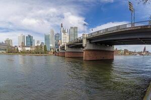 Panoramic picture of the Frankfurt skyline with Main and Friedensbruecke photo