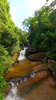 Smooth FPV flight over river and waterfall in the lush jungle in Thailand video