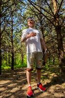 Man taking a break during walk in the woods. photo