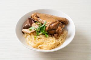 dried noodles with braised duck in white bowl photo
