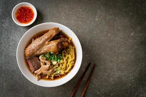 egg noodles with stewed and braised duck in brown soup photo