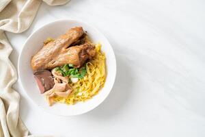 Egg noodles served dry with braised duck photo