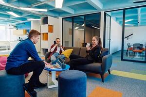 Multiethnic startup business team on meeting in a modern bright open space coworking office. Brainstorming, working on laptop. Group of coworkers walking around in motion blur photo
