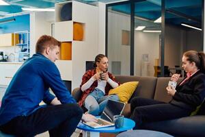 Multiethnic startup business team on meeting in a modern bright open space coworking office. Brainstorming, working on laptop. Group of coworkers walking around in motion blur photo