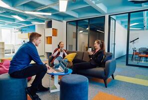 Multiethnic startup business team on meeting in a modern bright open space coworking office. Brainstorming, working on laptop. Group of coworkers walking around in motion blur photo