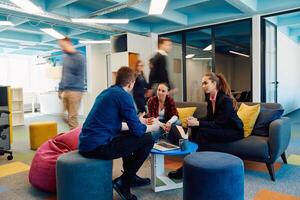 Multiethnic startup business team on meeting in a modern bright open space coworking office. Brainstorming, working on laptop. Group of coworkers walking around in motion blur photo