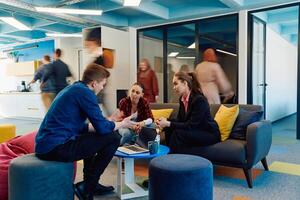 Multiethnic startup business team on meeting in a modern bright open space coworking office. Brainstorming, working on laptop. Group of coworkers walking around in motion blur photo