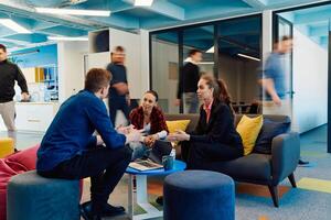 Multiethnic startup business team on meeting in a modern bright open space coworking office. Brainstorming, working on laptop. Group of coworkers walking around in motion blur photo