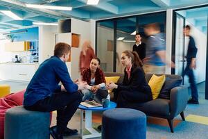 Multiethnic startup business team on meeting in a modern bright open space coworking office. Brainstorming, working on laptop. Group of coworkers walking around in motion blur photo