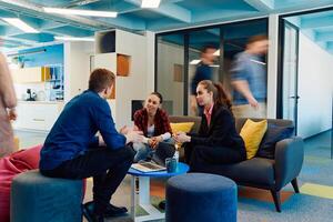 Multiethnic startup business team on meeting in a modern bright open space coworking office. Brainstorming, working on laptop. Group of coworkers walking around in motion blur photo