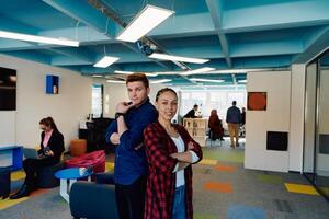Portrait of a successful creative businessman and businesswoman looking at camera and smiling. Diverse business people standing together at startup. photo