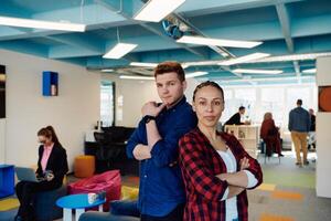 Portrait of a successful creative businessman and businesswoman looking at camera and smiling. Diverse business people standing together at startup. photo