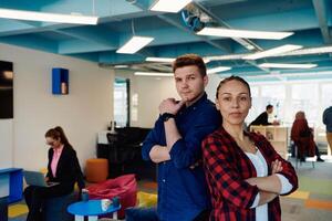 Portrait of a successful creative businessman and businesswoman looking at camera and smiling. Diverse business people standing together at startup. photo