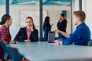 A team of successful programmers sits in a startup office, strategizing new business projects and solving existing challenges, showcasing innovation and collaboration in the tech industry photo