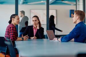 A team of successful programmers sits in a startup office, strategizing new business projects and solving existing challenges, showcasing innovation and collaboration in the tech industry photo