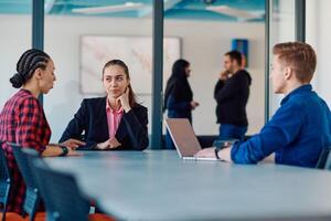 A team of successful programmers sits in a startup office, strategizing new business projects and solving existing challenges, showcasing innovation and collaboration in the tech industry photo