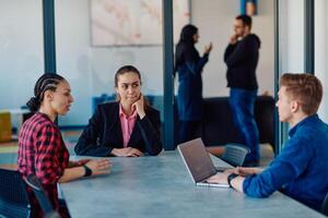 A team of successful programmers sits in a startup office, strategizing new business projects and solving existing challenges, showcasing innovation and collaboration in the tech industry photo