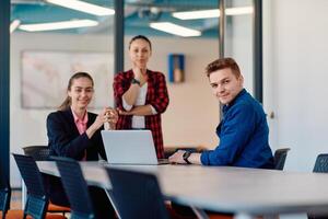 A team of successful programmers sits in a startup office, strategizing new business projects and solving existing challenges, showcasing innovation and collaboration in the tech industry photo
