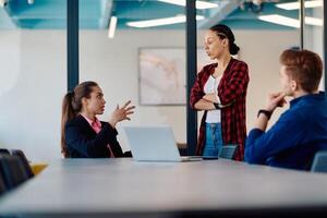 A team of successful programmers sits in a startup office, strategizing new business projects and solving existing challenges, showcasing innovation and collaboration in the tech industry photo