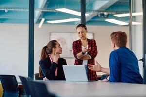 A team of successful programmers sits in a startup office, strategizing new business projects and solving existing challenges, showcasing innovation and collaboration in the tech industry photo