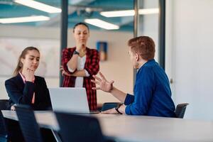 A team of successful programmers sits in a startup office, strategizing new business projects and solving existing challenges, showcasing innovation and collaboration in the tech industry photo