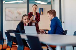 A team of successful programmers sits in a startup office, strategizing new business projects and solving existing challenges, showcasing innovation and collaboration in the tech industry photo