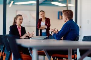 A team of successful programmers sits in a startup office, strategizing new business projects and solving existing challenges, showcasing innovation and collaboration in the tech industry photo