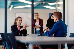 A team of successful programmers sits in a startup office, strategizing new business projects and solving existing challenges, showcasing innovation and collaboration in the tech industry photo